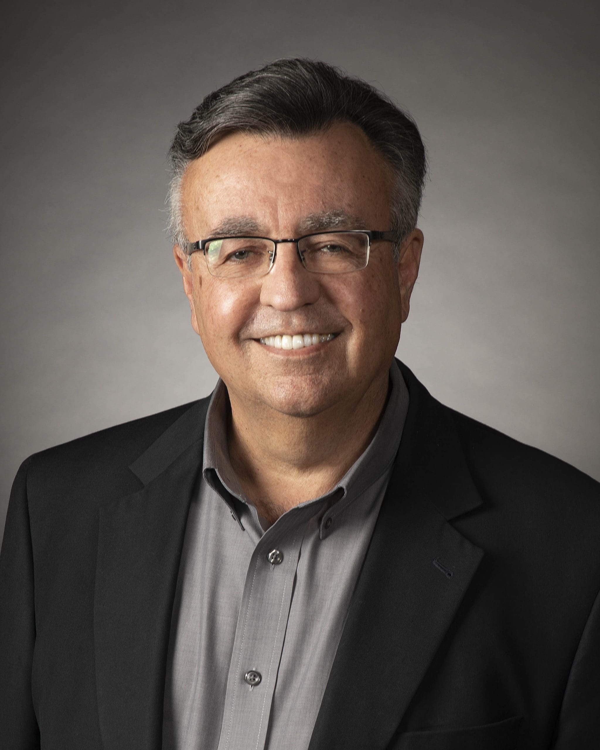Rich Bowen, a middle-aged man with glasses, gray hair, and a gray shirt under a black blazer, smiles at the camera against a plain background. He is a proud NACET Moonshot Mission Control Award Recipient.